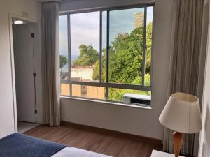 una camera da letto con una grande finestra con vista di Penthouse with private pool & amazing views a Salvador
