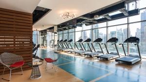 a gym with rows of treadmills and chairs at Jumeirah Marina Gate Residences in Dubai