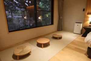a bedroom with two tables and a bed and a window at SPA TERRACE Shisui in Kobe