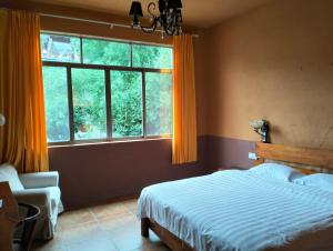 a bedroom with a bed and a large window at YangShuo Eden Inn in Yangshuo