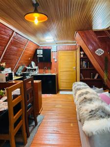 uma sala de estar com um sofá e uma cozinha em Aquawood Cabin em Keruguya