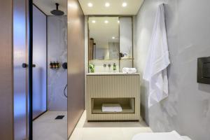 a bathroom with a sink and a toilet and a shower at Jewel TLV Hotel in Tel Aviv