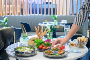 a table with plates of food on top of it at Jewel Boutique Hotel by The Beach in Tel Aviv +89 photos