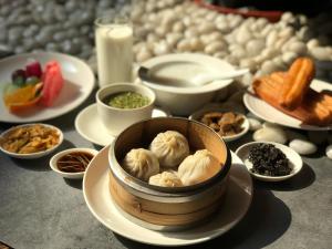 a table topped with plates of food with dumplings at InterContinental Wuxi, an IHG Hotel in Wuxi