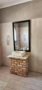 een badkamer met een wastafel en een spiegel bij Cielo Guestfarm in Swartruggens