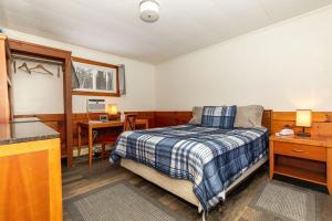 1 dormitorio con cama, escritorio y mesa en West Bethel Motel, en Bethel