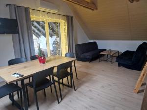 uma sala de estar com uma mesa de madeira e cadeiras em Agroturystyka Bocian Biały em Kiwity