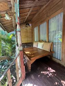 porche de madera con banco en la cubierta en Umakayu Joglo Villa Canggu - Boutique Hotel en Canggu