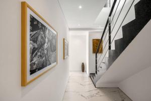 a hallway with black and white pictures on the wall and stairs at Golden Lotus Villas in Amphoe Koksamui