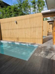 a swimming pool in front of a wooden wall at RINA Poolvilla (รินะ พูลวิลล่า) in Hat Yai +14 photos