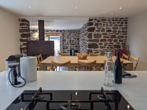 cocina con fogones y mesa con sillas en Maison de Vacances L'Etable, en Saint-Just-près-Brioude