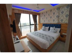 a bedroom with a large bed and a large window at Hotel Mountview, Family Hotels In Vadodara in Vadodara