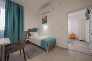 a bedroom with a bed and a desk and a table at AS APARTMANI PIROT in Pirot