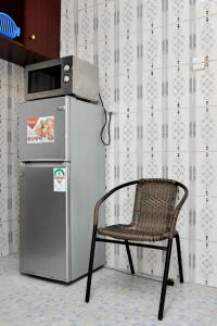 a chair sitting next to a refrigerator in a room at Ramsi apartment in Nairobi