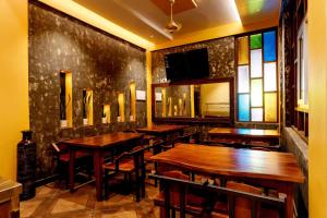 un restaurante con mesas de madera y vidrieras en Casa Bella, Thekkady, en Thekkady