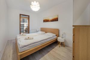 a bedroom with a bed and a chandelier at Beach&Nature - Bursztynowa in Gdańsk