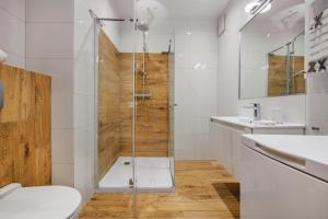 a bathroom with a shower and a toilet and a sink at Beach&Nature - Bursztynowa in Gdańsk +17 photos
