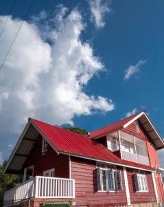 una casa roja con techo rojo en Bohang cottage, en Hāpoli