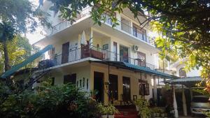 a large white building with a balcony at Little Swan Guest house in Bentota