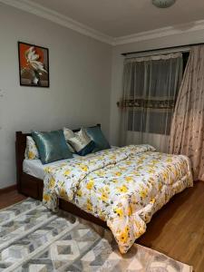 a bedroom with a bed with a yellow and white comforter at Rose house in Dar es Salaam