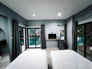 a bedroom with a white bed and large windows at Skybird lake view Resort&Camping Khaoyai in Khanong Phra