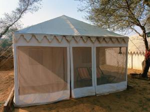 a white tent with a chair inside of it at Elefun Resort with organic farm in Middle of Nature in Jaipur