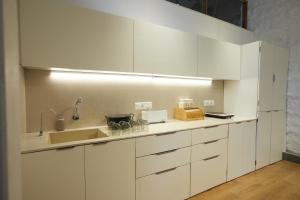 a kitchen with white cabinets and a sink at Souzagad - Villa Maria in Pune