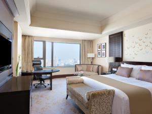 InterContinental Wuxi, an IHG Hotel في ووشي: غرفة الفندق بسرير كبير ومكتب