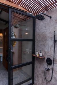 a shower in a bathroom with a glass door at IPIAN Angel by Pramana Villas in Ubud