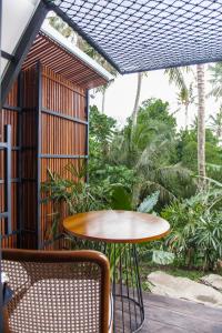a patio with a table and chairs and a window at IPIAN Angel by Pramana Villas in Ubud
