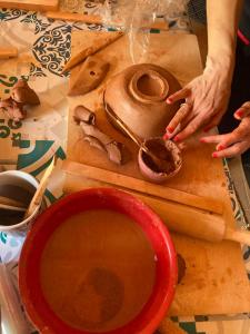 a person making a pot on a cutting board with a bowl at Ecologic glamping in Estevais +46 photos