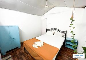 een kleine slaapkamer met een bed en een blauwe kast bij Palolem Hideout in Canacona