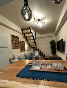 comedor y sala de estar con mesa y escaleras en Mentha Luxury Home, en Lefkogeia