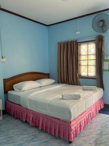 2 letti in una camera da letto con pareti blu e finestra di Adam Bungalows a Krabi town