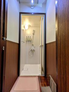 uma casa de banho com um chuveiro e uma porta de vidro em 駿府城下町の宿　玉乃屋 em Shizuoka