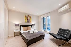a bedroom with a bed and a chair at Beautiful 2-bed flat-Hosted by Sweetstay in London