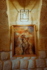 een schilderij dat aan een bakstenen muur hangt met een licht bij Misty Cave Hotel in Urgup