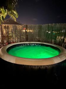 una piscina verde con una valla alrededor por la noche en villa cocooning and spa, en La Possession