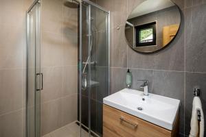 a bathroom with a sink and a shower with a mirror at Hotel Granit Smrekovica in Liptovská Osada