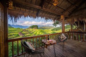 eine Veranda mit 2 Stühlen und einem Tisch mit Aussicht in der Unterkunft Puluong Valley Home in Thanh Hóa