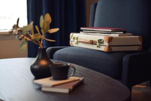 a stack of books and a vase with a cup of coffee and a table at NOHGA HOTEL UENO TOKYO in Tokyo