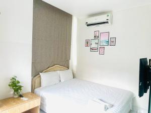 a bedroom with a bed and a air conditioner at Wind Hotel in Ho Chi Minh City