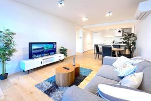 a living room with a couch and a tv at Brilliant Quay Blvd Apt Close to Wyndham Harbour in Werribee South