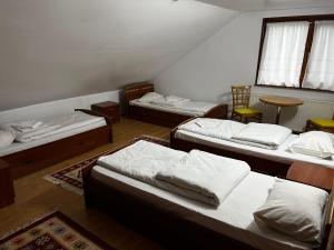 JieţにあるCabana Mijaのベッド3台とテーブルが備わる部屋