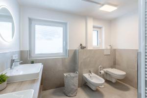 Un baño blanco con lavabo e inodoro. en Chalet Hosp Reutte, en Reutte 48 fotos más