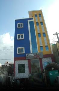 een hotelgebouw waar mensen voor staan bij Hotel M in Vijayawāda