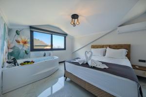 1 dormitorio con bañera y 1 cama con lavamanos en Villa Lotus Sea, en Fethiye