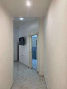 un corridoio vuoto con una porta e una televisione su un muro di Napoli Hub a Napoli