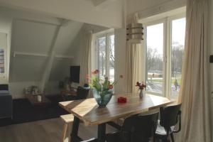 una mesa de comedor con un jarrón de flores. en Park View Apartment, en Ámsterdam