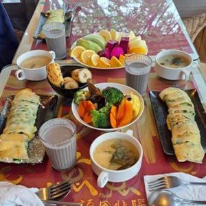 une table recouverte d'assiettes de nourriture et de tasses de café dans l'établissement Rainbow Bridge B&B, à Sanzhi